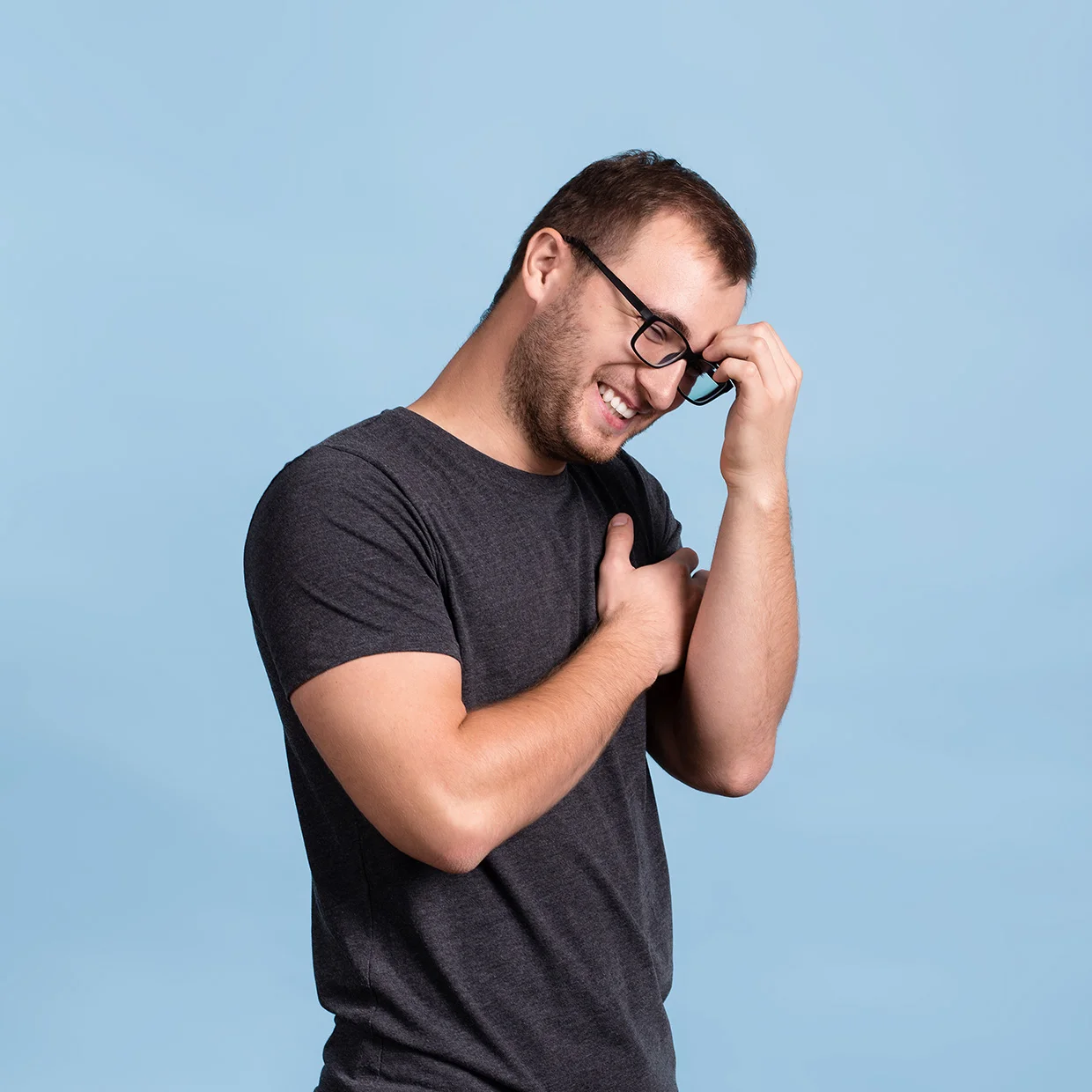 Улыбающийся мужчина в очках и темной футболке на синем фоне