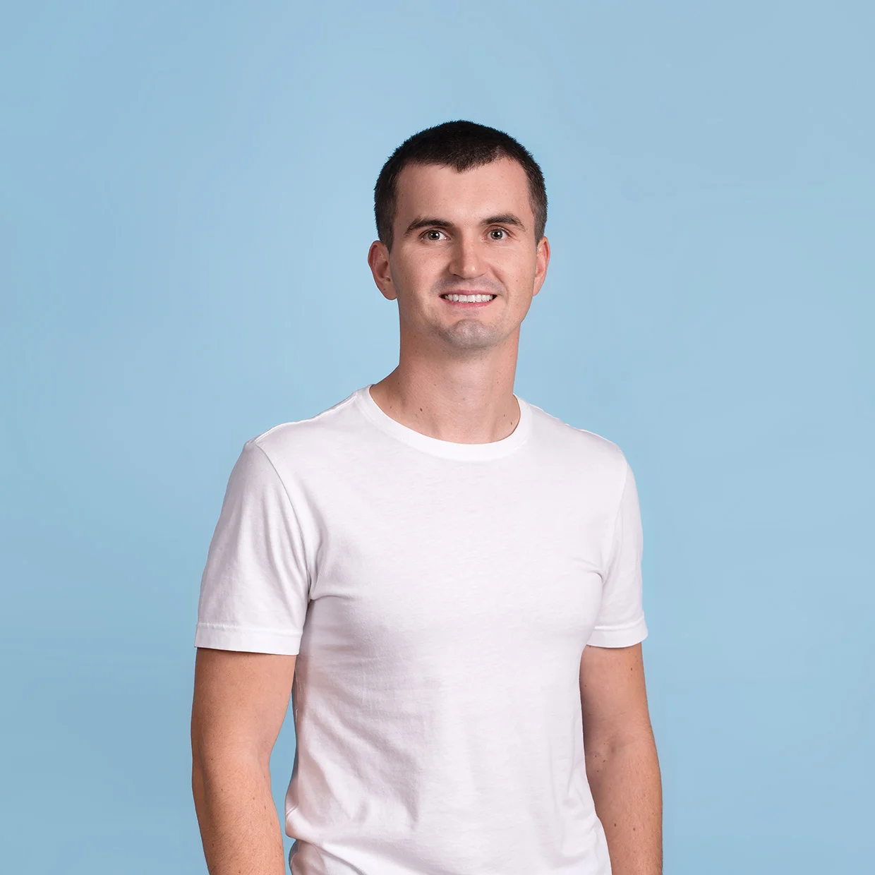 Улыбающийся мужчина в белой футболке на синем фоне
